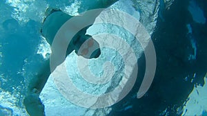 Man swimmer take an action camera from pool bottom