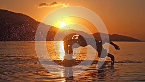 Man Swimming at amazing sunset background jumping and diving to sea in slow motion. 1920x1080