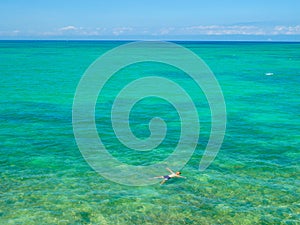 A man swimming, floating on an infinite ocean.