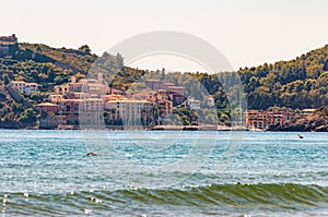 Man swimming in the sea with the landscape cityscape view of the Poggio Pertuso in the front of the Tenda Gialla beach in Province photo