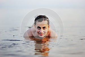 Man swimming in sea at sunset