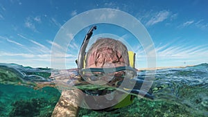 A man swimming on the sea surface the background of blue sky