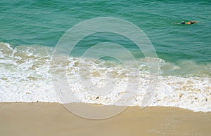 Man swimming in the wavy Atlantic ocean, Copacabana beach, Rio de Janeiro, Brazil