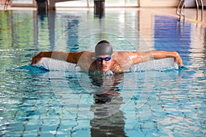 Man swims butterfly style in public swimming pool