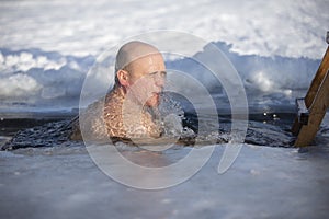 A man swims in the ice-hole in winter. Walrus people