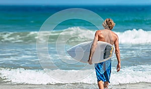 Man in swimsuit holding a surfboard