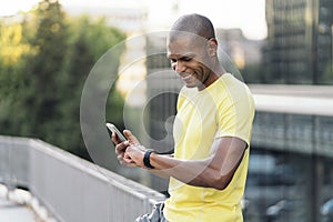 Man synchronizing cellphone and smartwatch to do sports in the city