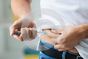 Man with syringe making insulin injection