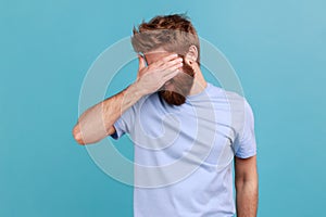 Man in T-shirt covering eyes and turning with disgust from something shameful, scared afraid to see.