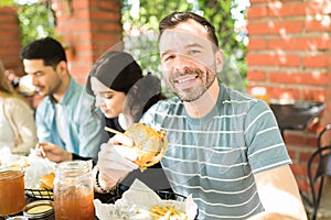 Man In T-shirt Having Cheeseburger At Restaurant