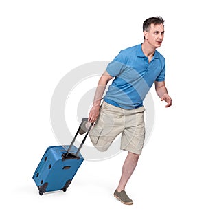 Man in a T-shirt, shorts and with a suitcase hurries, runs. Isolated on white background.
