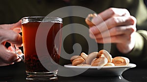 A man at the table drinks tea with bagels. Slow motion