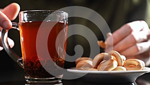 A man at the table drinks tea with bagels. Slow motion