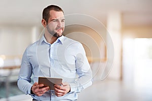 Man with tablet computer looking to the side in the business center