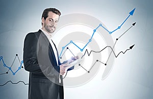 Man with tablet and growing graphs