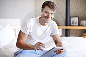 Man, tablet and pajamas for morning, routine and book in bedroom for wellness and digital for class. Male person, hobby