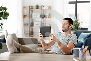 Man with tablet pc and earphones at home