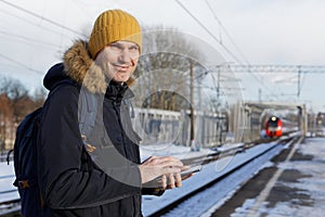 Man with a tablet on a station platform