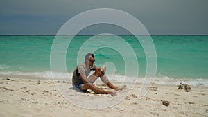 Man with a tablet on a tropical beach.