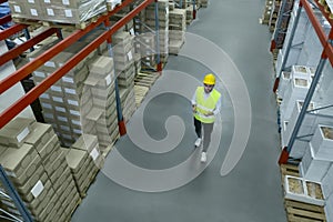Man with tablet working at warehouse, above view. Logistics center