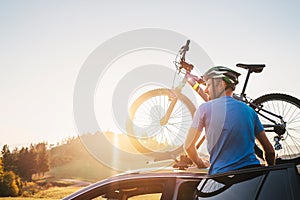 Man take his bicycle from car roof. Mountain biking concept