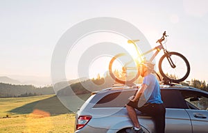 Man take his bicycle from car roof. Mountain biking concept