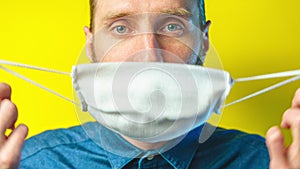 Man take off a gauze antivirus mask