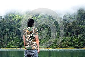 Man take a view of dense tropical rainforest at Rajjaprabha Dam or Cheow Lan Dam Guilin of Thailand