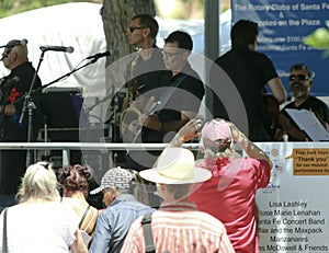 A Man Takes a Cell Phone Photo of the band Manzanares in Santa F