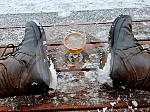 a man takes a glass of beer and toasts his health in the middle of winter