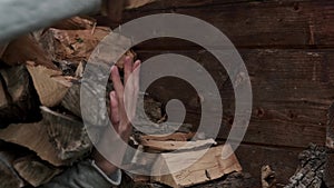 A man takes logs from a woodcutter in his hands for heating in the house. Man is ready for the cold.