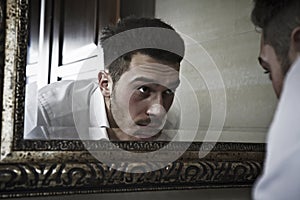 Man takes a look at himself in the mirror. photo