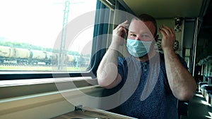 Man takes off his medical mask on the train