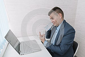 man takes off his protective mask against white background. end of the coronavirus pandemic. Quarantine is over. fatigue