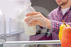 Man takes out bottle of milk from refrigerator