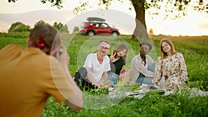 Man takes Photo by analogue Camera to Diverse people outdoors in summer