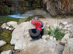 Man takes a photo of Falls in the Ein Gedi Nature Reserve