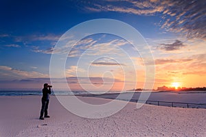 Man takes a photograph of sunrise