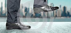 Man takes step in classic shoes. Motivation and challenging. Close up legs of businessman walking stepping up stair in modern city