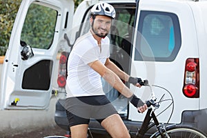 man taking bicycle out from trunk