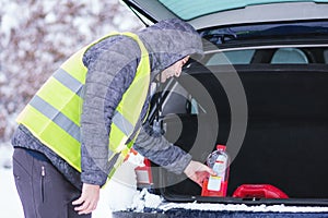 Man taking bottle of antifreeze coolant luggage of his car.