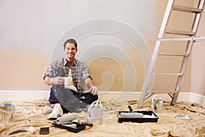 Man Taking A Break Whilst Decorating Room