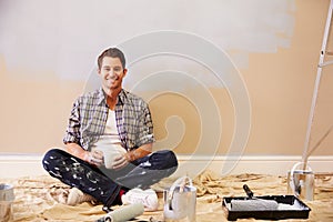 Man Taking A Break Whilst Decorating Room
