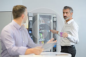 Man taking coffee from vending machine