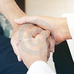 Man taking the hand of a senior patient