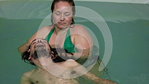 Man taking head massage in swimming pool