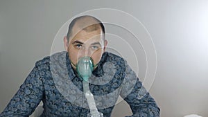 A man taking inhalation. Use a nebulizer and inhaler for treatment. Sick person inhales through inhaler mask. Quarantine