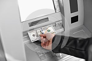 Man taking money from cash machine outdoors