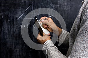 Man taking notes of math theorem on blackboard