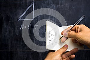 Man taking notes of math theorem on blackboard photo